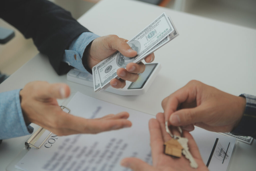 Cash home buyer hands money while receiving house keys during a direct home sale in Nevada.